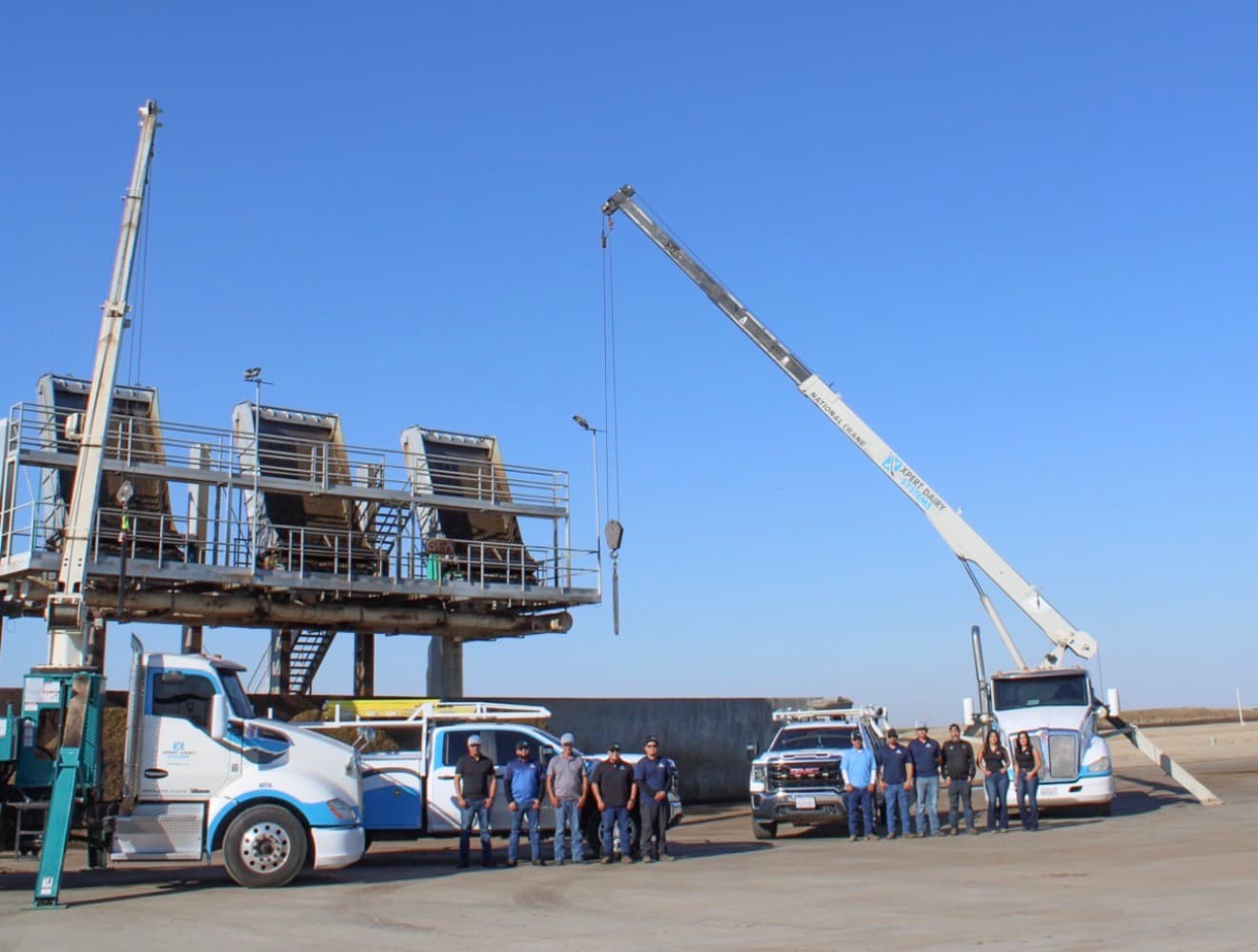 XDS crew and service trucks beneath a dairy manure separator platform